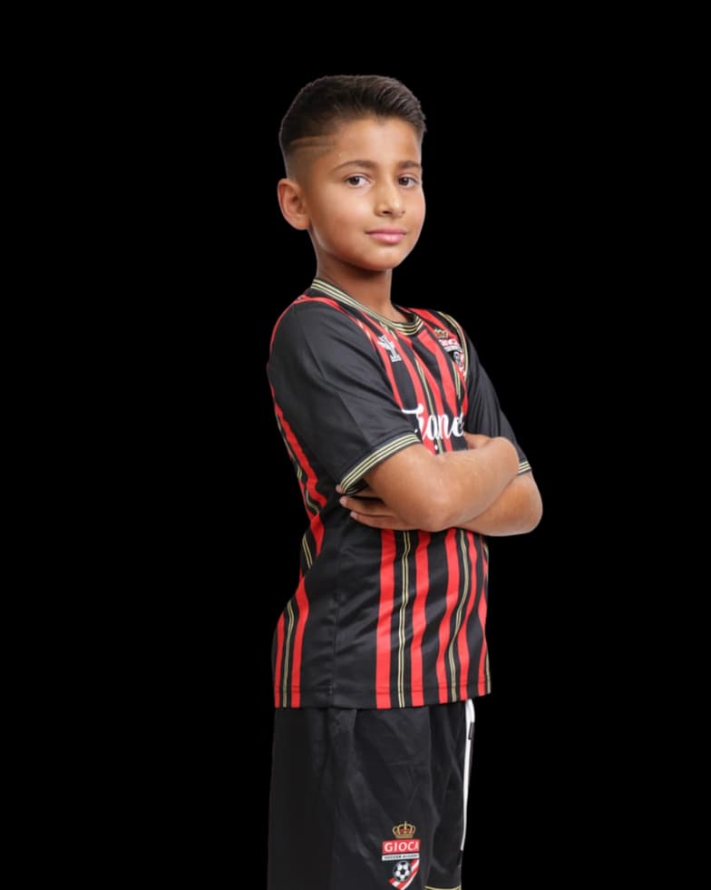Young Gioca player in the academy's red and black kit