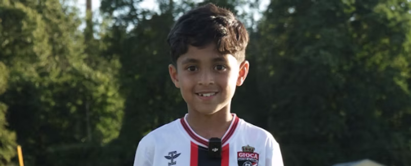 A young soccer player smiling at training