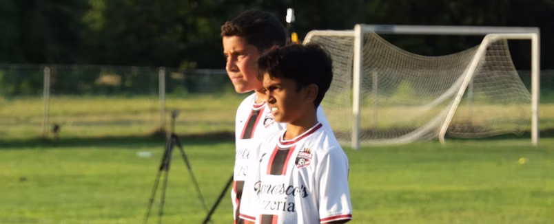 A Gioca coach guiding a young player on the field