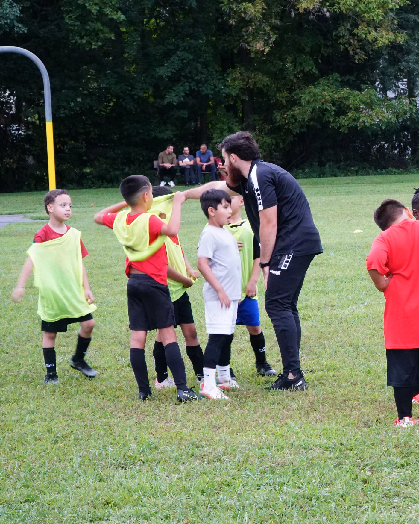 A Gioca coach coaching a small group of players in training bibs