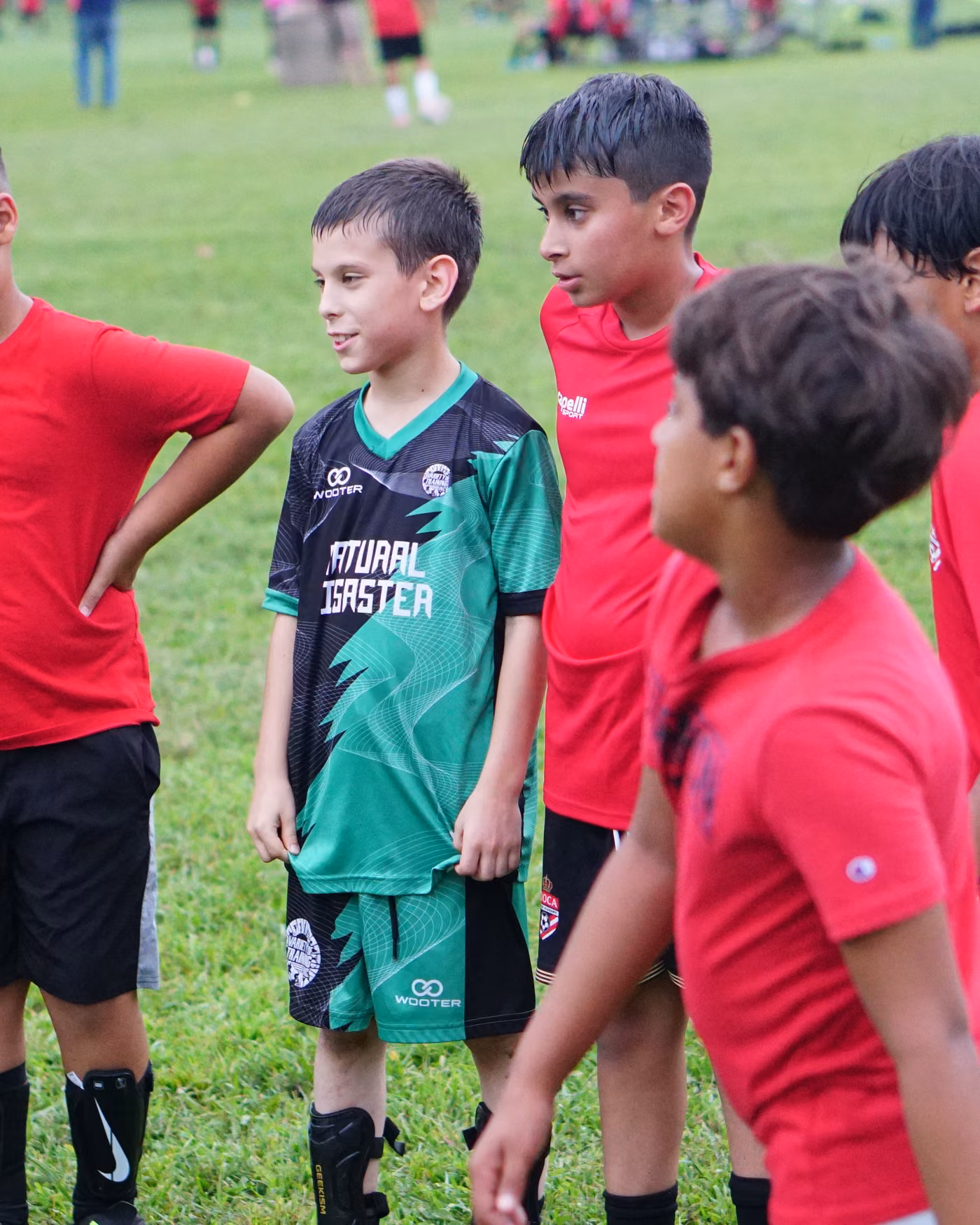 Gioca players in red training shirts standing together on the pitch